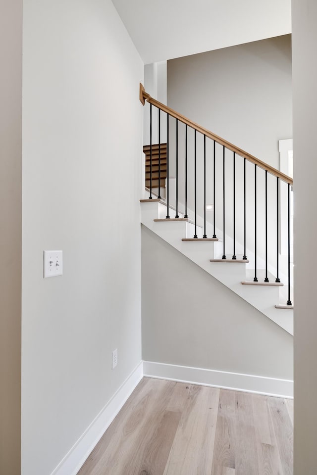 stairway featuring baseboards and wood finished floors