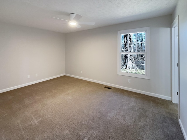 spare room with visible vents, a ceiling fan, carpet flooring, a textured ceiling, and baseboards