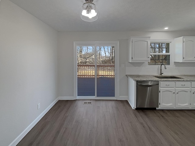 kitchen with a sink, white cabinetry, baseboards, stainless steel dishwasher, and dark wood-style floors