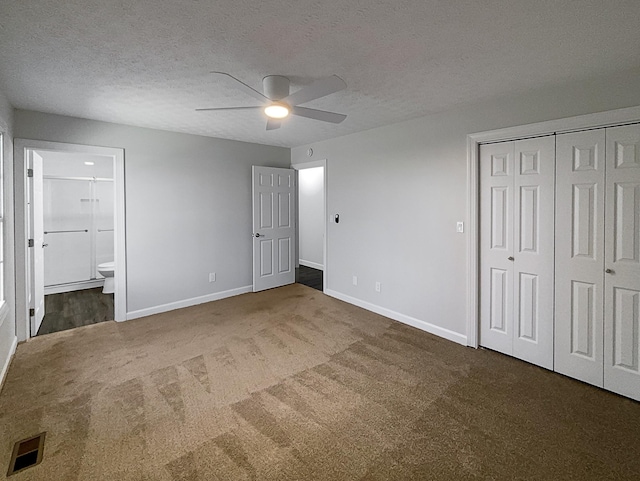 unfurnished bedroom featuring a textured ceiling, connected bathroom, carpet flooring, visible vents, and baseboards