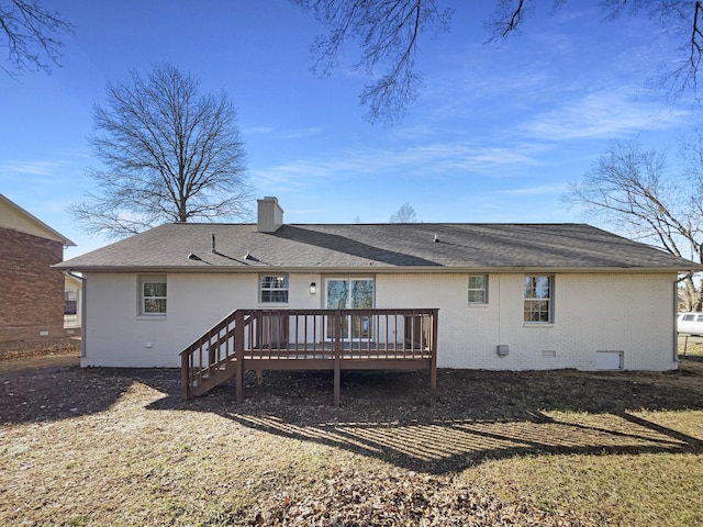 rear view of property with brick siding, a chimney, a shingled roof, crawl space, and a deck