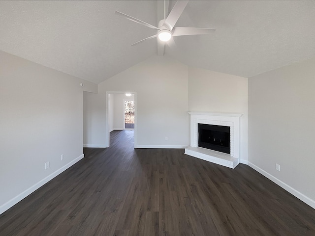 unfurnished living room with baseboards, a ceiling fan, lofted ceiling, dark wood-style floors, and a brick fireplace