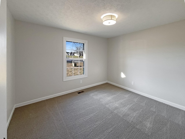 carpeted empty room featuring a textured ceiling, visible vents, and baseboards