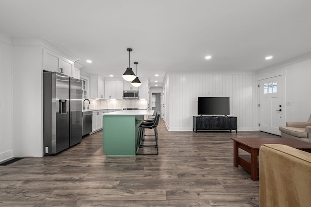 kitchen with dark wood finished floors, stainless steel appliances, light countertops, open floor plan, and white cabinetry