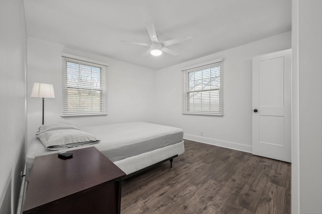 bedroom with dark wood-style floors, ceiling fan, multiple windows, and baseboards