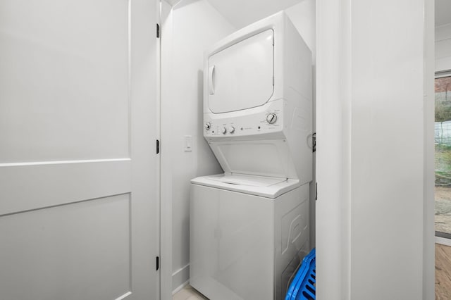 washroom with stacked washer and clothes dryer and laundry area