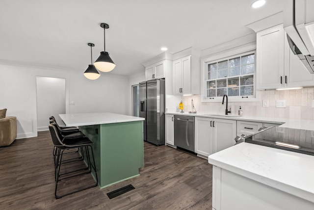 kitchen with visible vents, appliances with stainless steel finishes, backsplash, and a sink