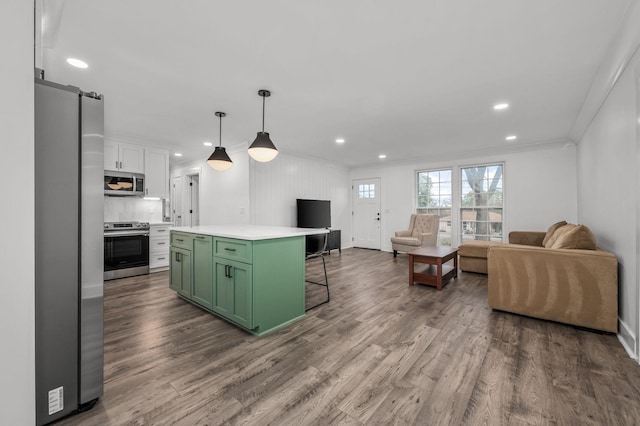 kitchen featuring dark wood finished floors, appliances with stainless steel finishes, open floor plan, light countertops, and green cabinets