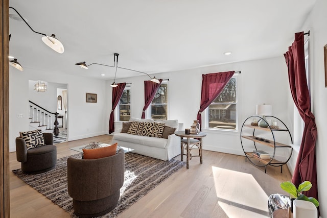 living room featuring stairs, recessed lighting, light wood-type flooring, and baseboards