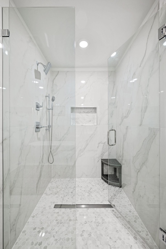 full bathroom with a marble finish shower and recessed lighting