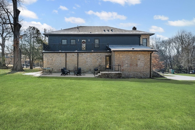 rear view of property featuring a chimney, a patio, and a yard