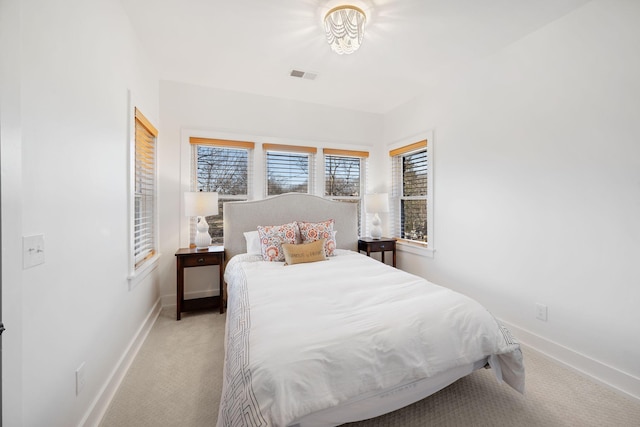 bedroom featuring light carpet, visible vents, and baseboards