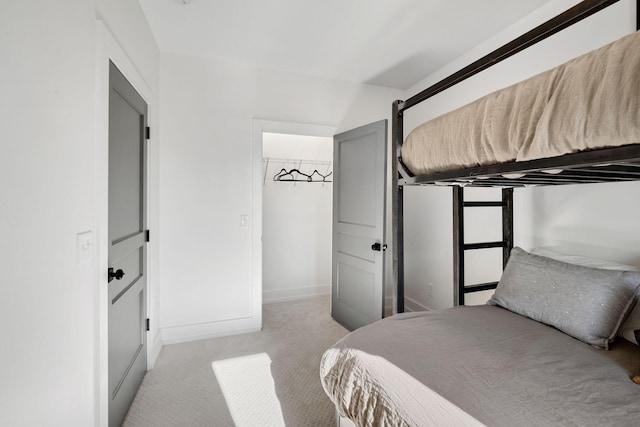 bedroom featuring light carpet and baseboards