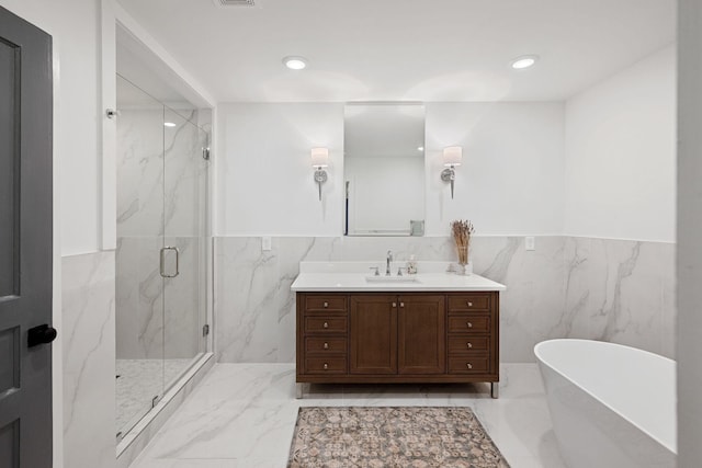 bathroom featuring recessed lighting, vanity, marble finish floor, a soaking tub, and a marble finish shower