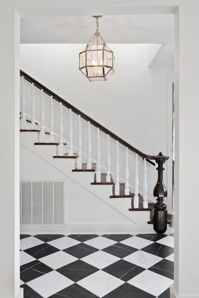 stairway with an inviting chandelier and visible vents