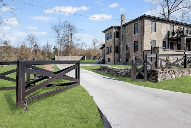 view of gate featuring fence and a lawn