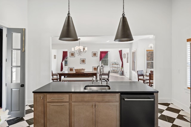 kitchen featuring dark countertops, dark floors, pendant lighting, and a sink