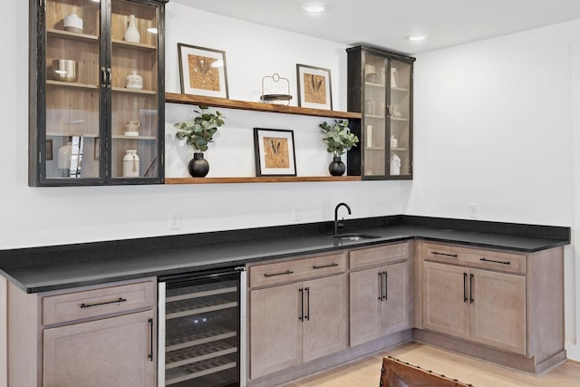 bar featuring recessed lighting, beverage cooler, a sink, light wood-style floors, and wet bar