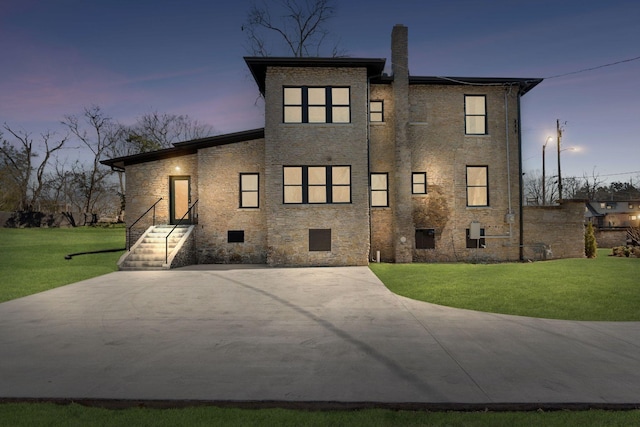 view of front facade with a chimney and a front lawn