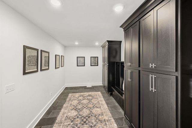 hall featuring recessed lighting and baseboards