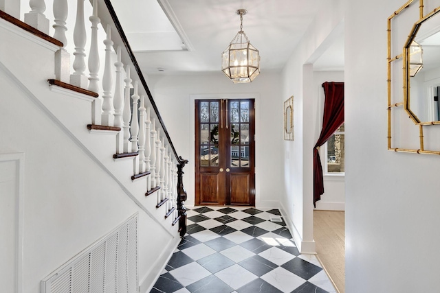 entryway with a notable chandelier, visible vents, stairway, baseboards, and tile patterned floors