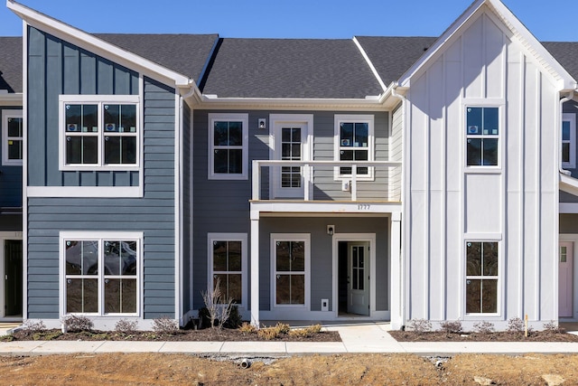 view of front of house with board and batten siding, a shingled roof, and a balcony