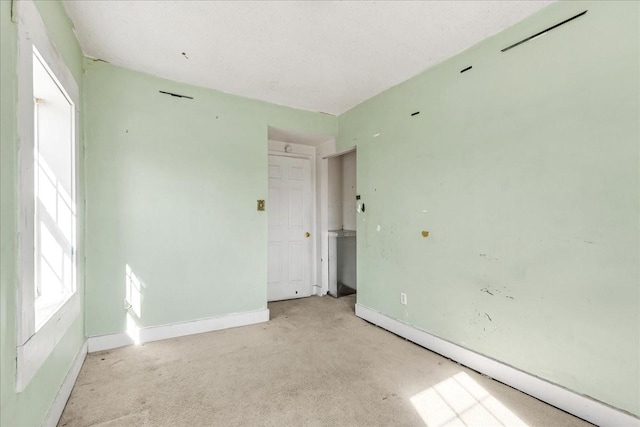 empty room featuring carpet and baseboards