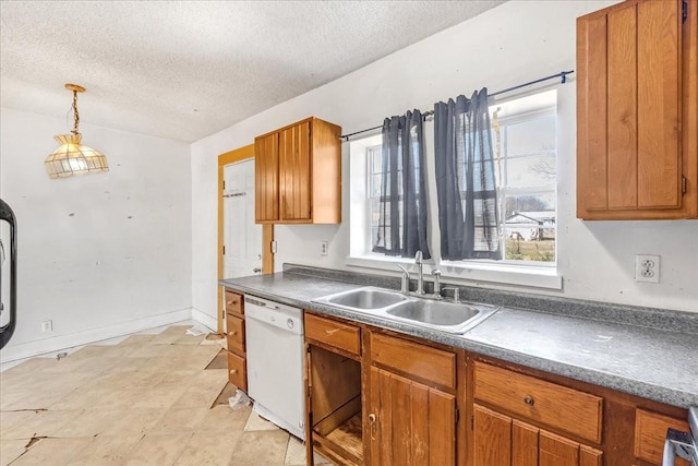 kitchen with brown cabinetry, dishwasher, dark countertops, hanging light fixtures, and a sink