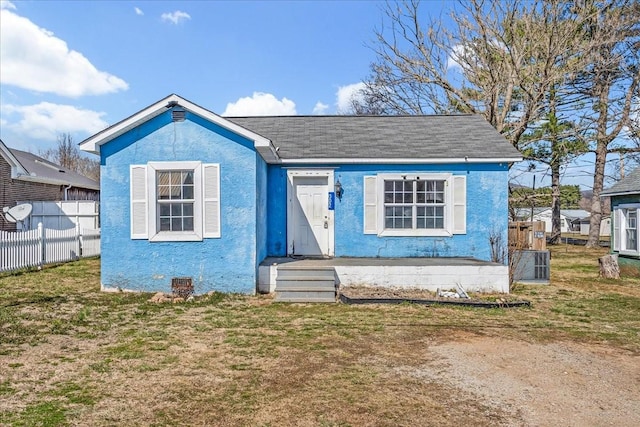 bungalow-style house with crawl space, fence, a front lawn, and stucco siding