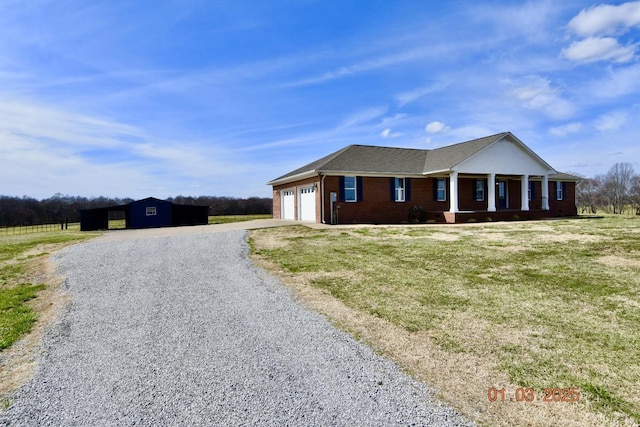 view of front facade featuring a garage, a front yard, brick siding, and driveway