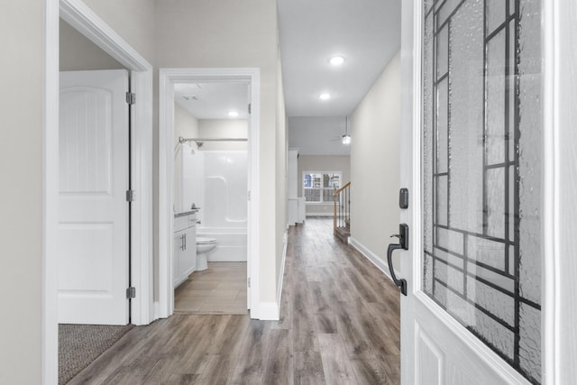 entrance foyer featuring stairs, baseboards, and wood finished floors