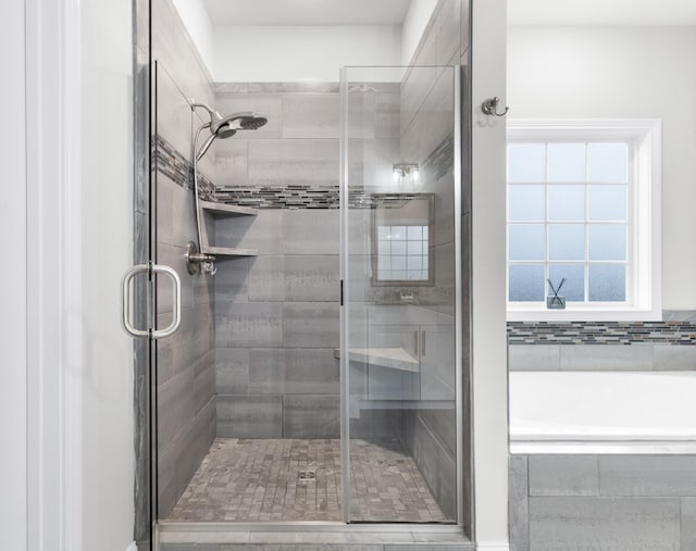 bathroom featuring a stall shower and a garden tub