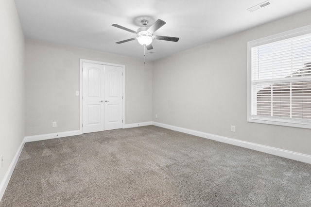 unfurnished bedroom featuring baseboards, a closet, visible vents, and carpet flooring