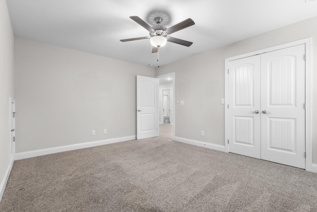 unfurnished bedroom featuring carpet, baseboards, ceiling fan, and a closet