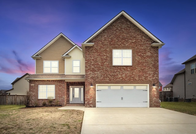 traditional home with driveway, a yard, a garage, and brick siding