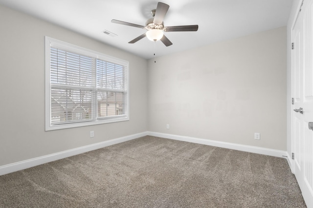 unfurnished room with carpet, visible vents, and baseboards