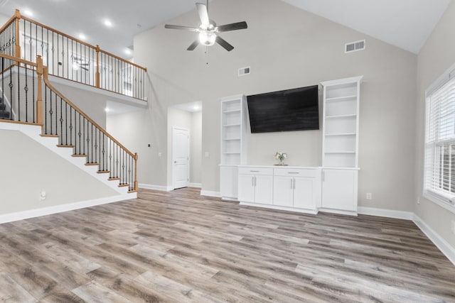 unfurnished living room featuring visible vents, stairway, and wood finished floors