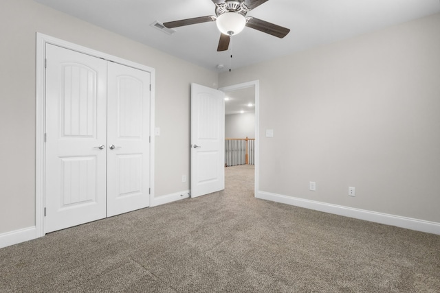 unfurnished bedroom featuring carpet floors, baseboards, visible vents, and a closet