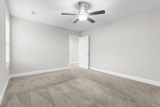 empty room with a ceiling fan, carpet, visible vents, and baseboards