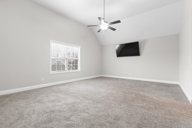 empty room featuring ceiling fan, baseboards, vaulted ceiling, and carpet flooring