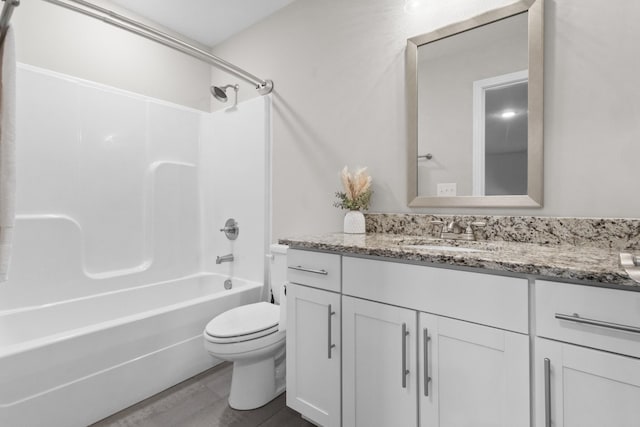 bathroom featuring toilet, washtub / shower combination, wood finished floors, and vanity