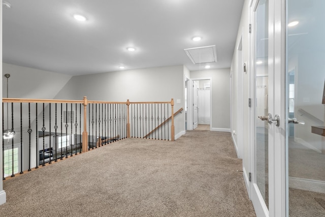 carpeted empty room with baseboards, attic access, and recessed lighting