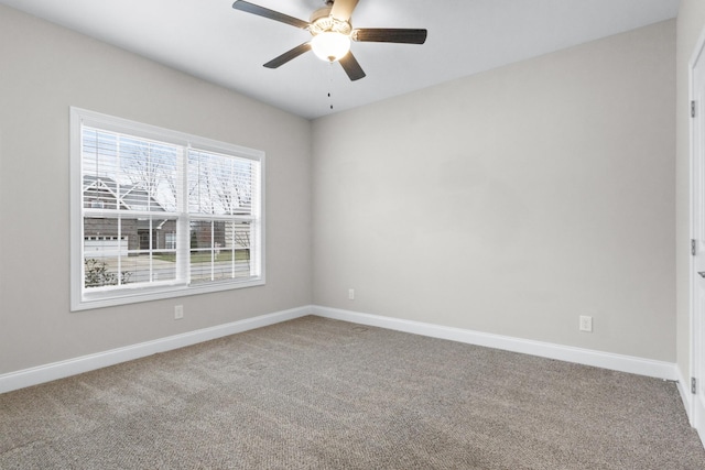 carpeted empty room with baseboards and a ceiling fan