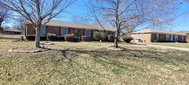 single story home with brick siding and a front yard