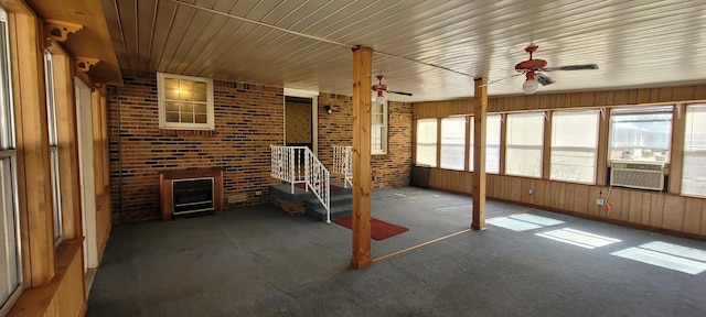 unfurnished sunroom with plenty of natural light, cooling unit, a fireplace, and ceiling fan