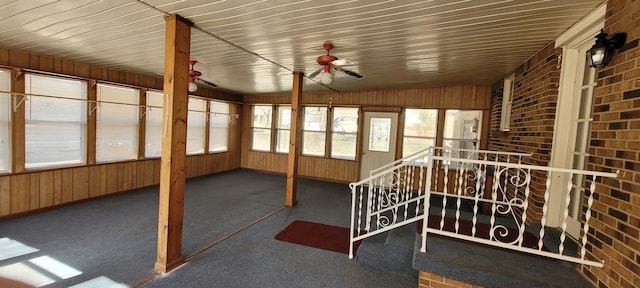 unfurnished sunroom with a ceiling fan