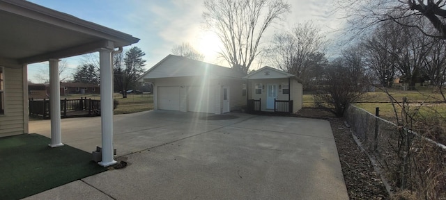 view of front facade featuring a garage, fence, and driveway