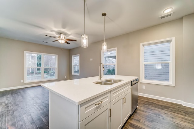 kitchen with pendant lighting, visible vents, open floor plan, a sink, and dishwasher