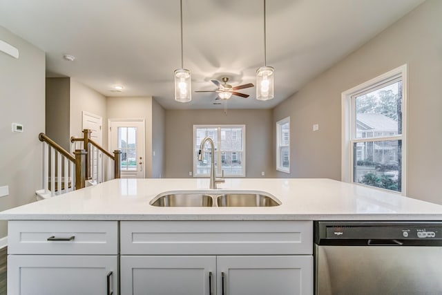 kitchen featuring pendant lighting, white cabinets, dishwasher, and a sink