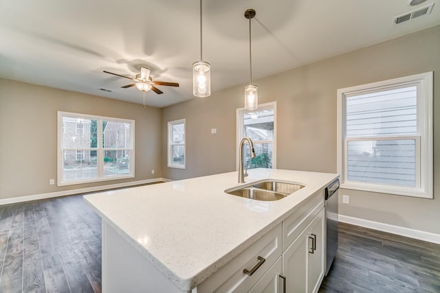 kitchen with decorative light fixtures, visible vents, stainless steel dishwasher, open floor plan, and a sink